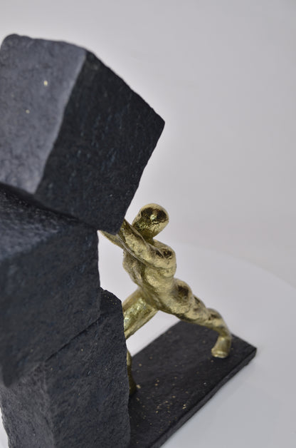 Vertical gold human struggle sculpture pulling textured sphere on stepped base