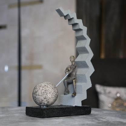 bronze figure pulling sphere on textured steps sculpture