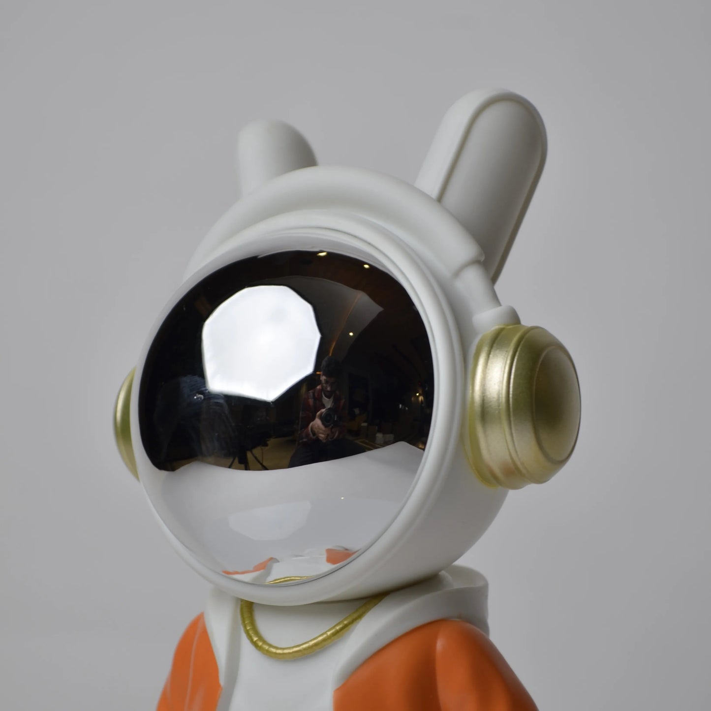 Astronaut figurine with orange jacket and chrome visor.