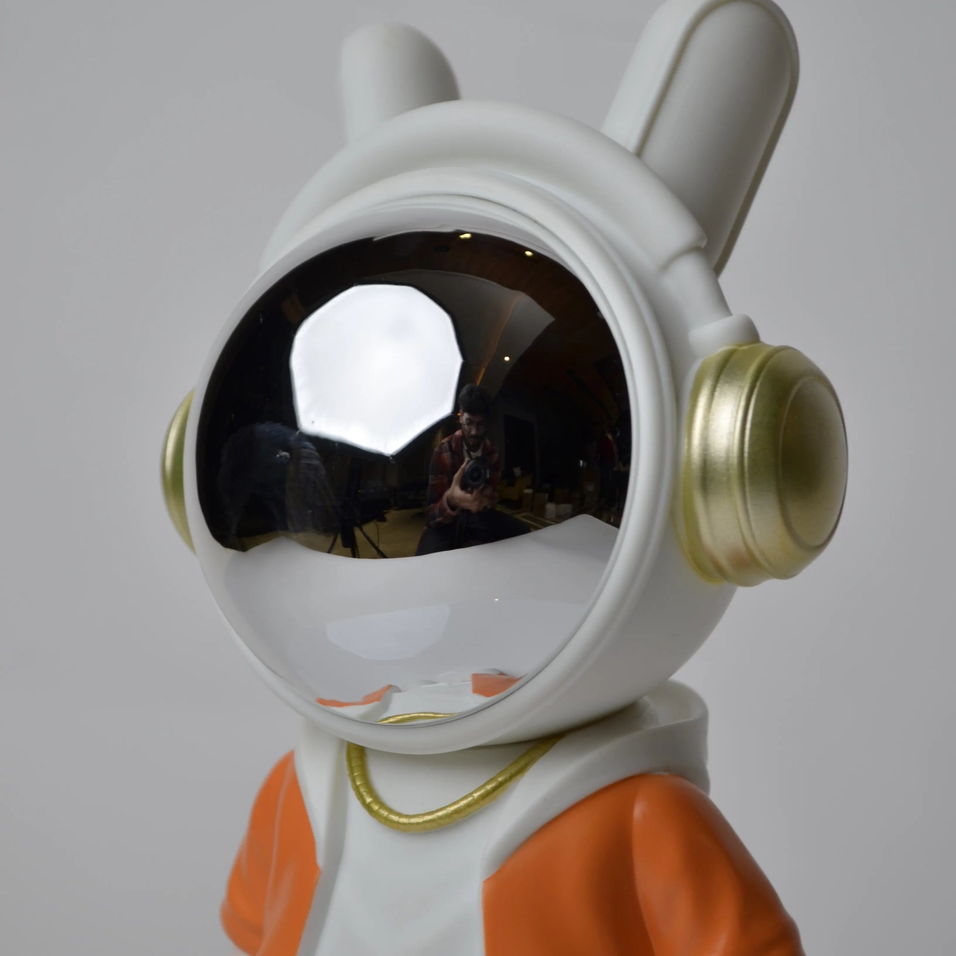 Astronaut figurine with orange jacket and chrome visor.