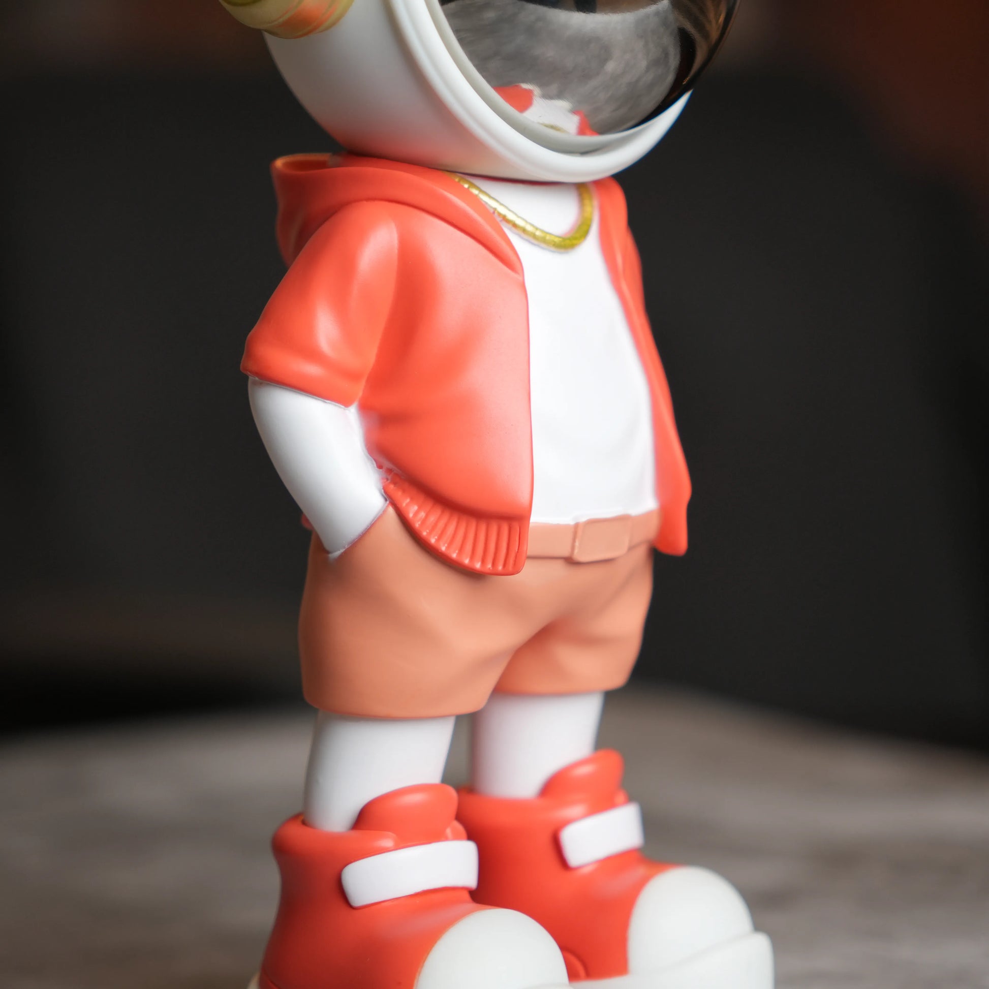 Astronaut figurine with coral jacket and chrome visor.