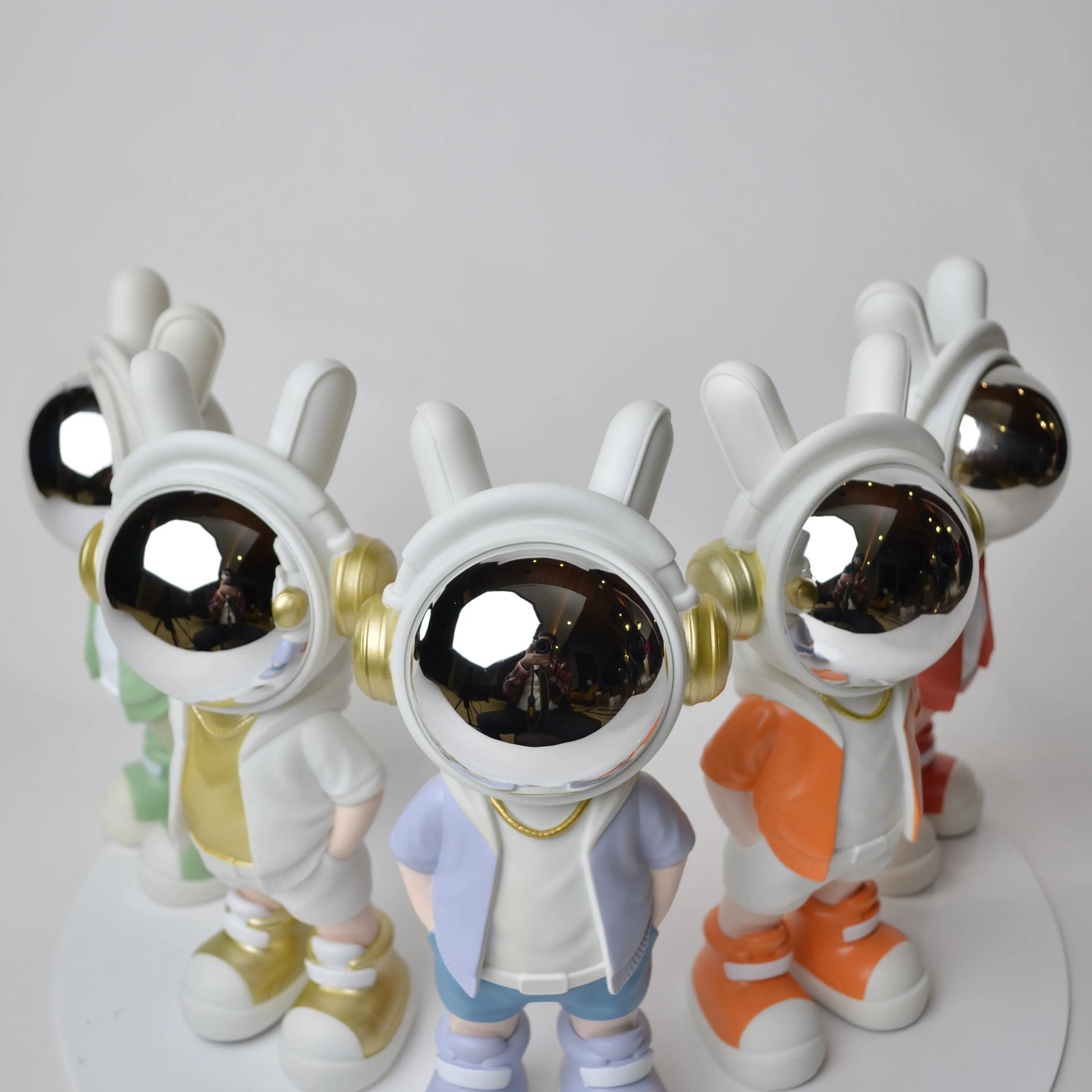 Astronaut figurine with chrome visor wearing blue shorts and lavender jacket.