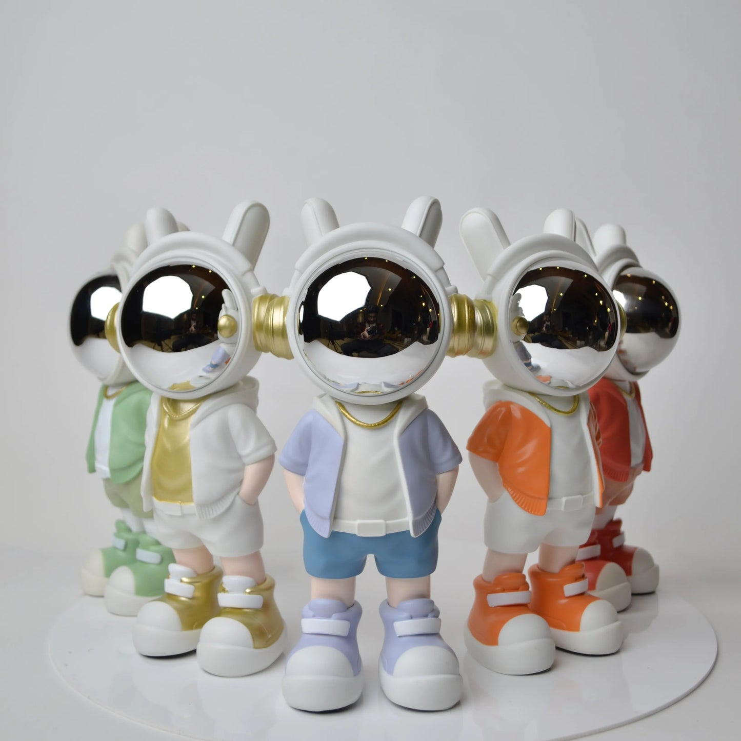 Astronaut figurine with chrome visor wearing blue shorts and lavender jacket.