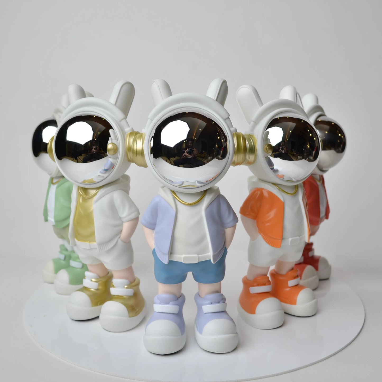 Astronaut figurine with chrome visor wearing blue shorts and lavender jacket.