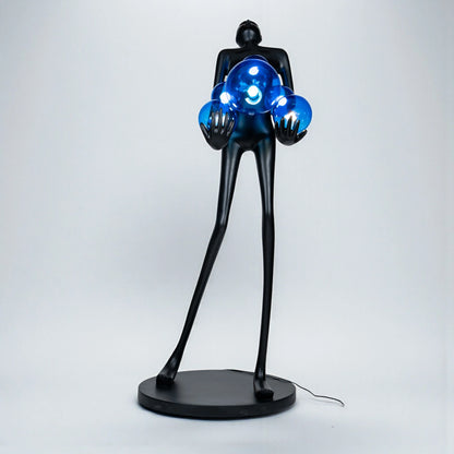 Tall matte black sculpture of human figure holding glowing blue light spheres — Azure Radiance Sculpture by Ghar Art, handcrafted illuminated modern home decor accent.