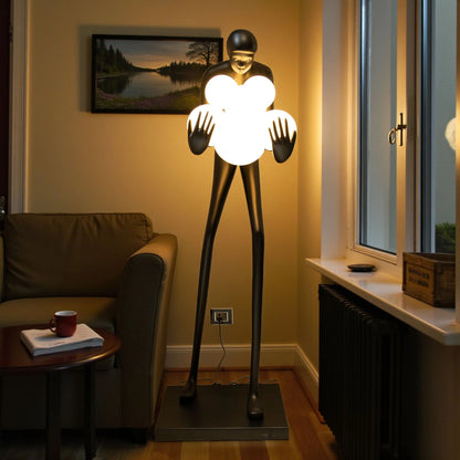 Tall matte black human sculpture holding glowing white orbs
