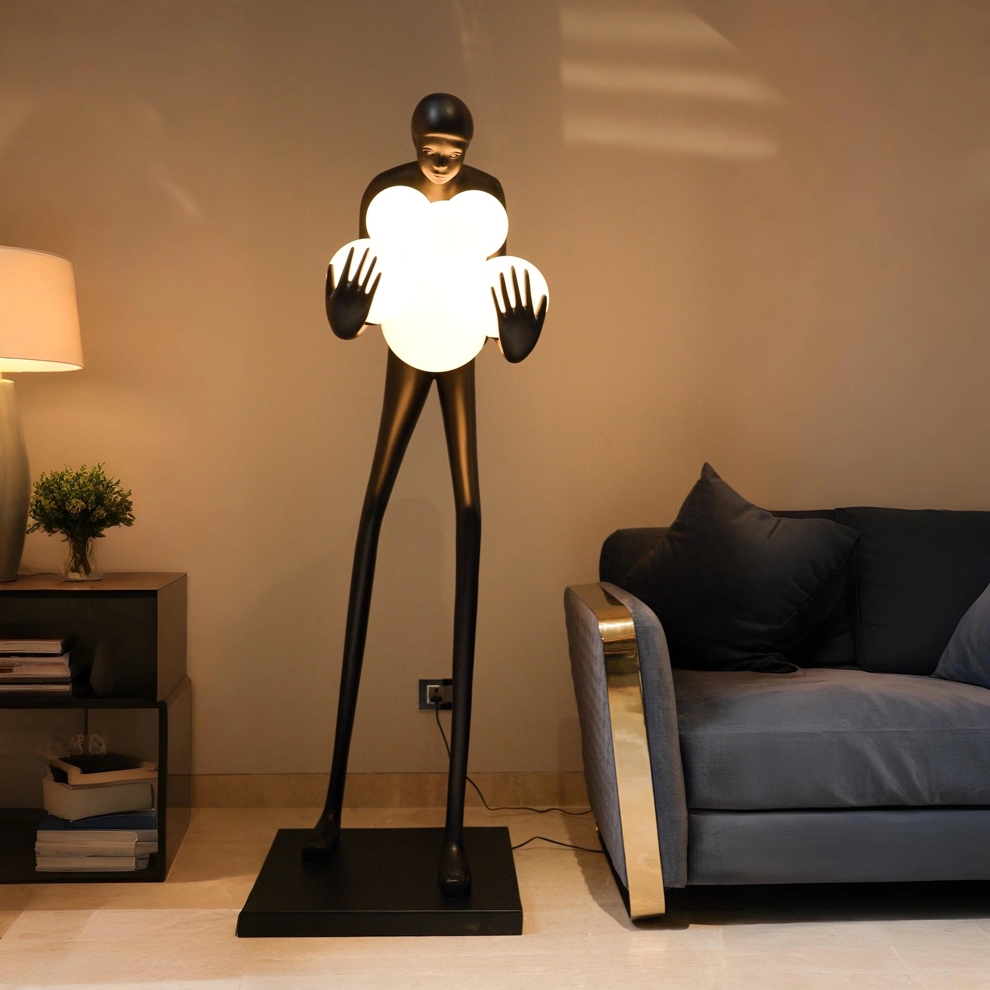 Tall matte black human sculpture holding glowing white orbs