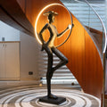 Tall black resin luminous poise sculpture with glowing LED halo — The Illuminated Voyager Sculpture by Ghar Art, handcrafted luxury home decor, 190 cm tall statement art piece.