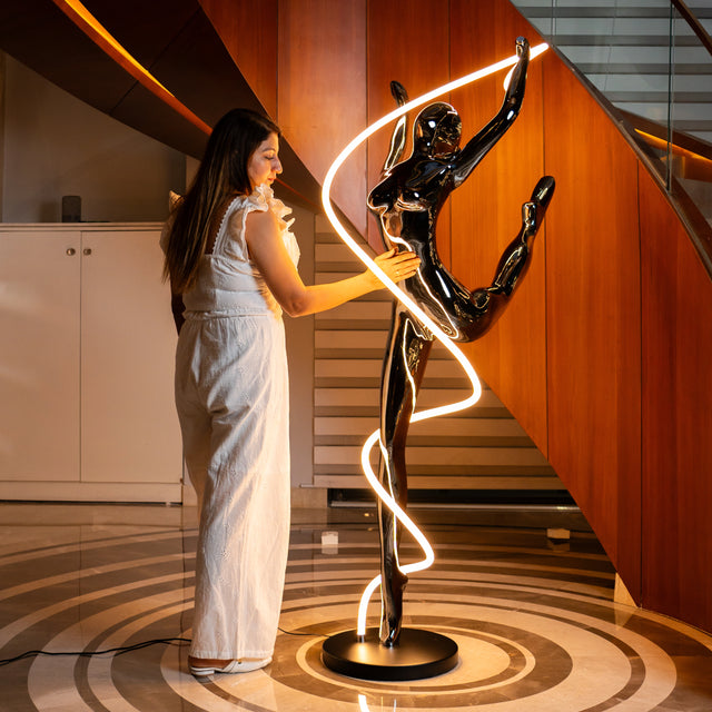 Metallic black human spiral floor sculpture with integrated LED light