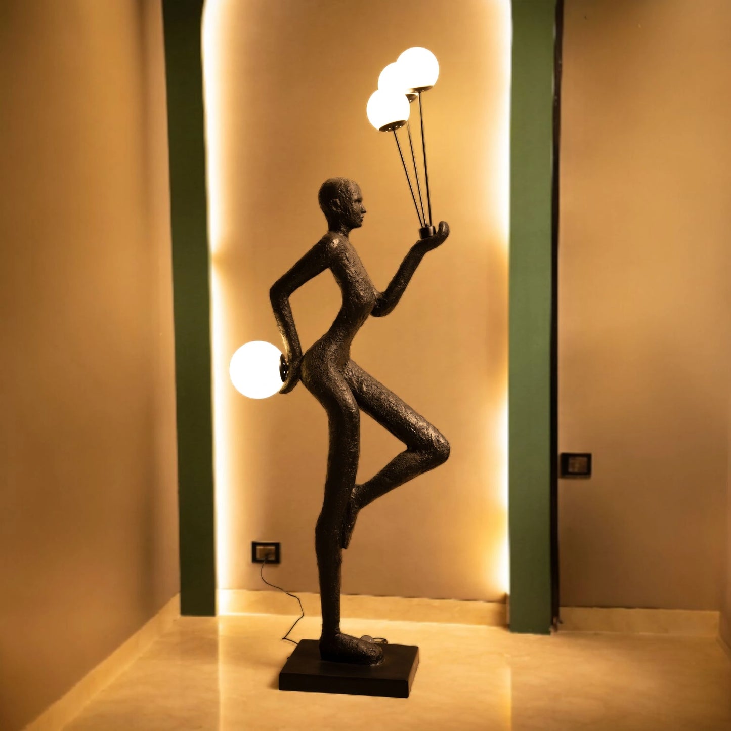 Matte black human-form sculpture holding illuminated orbs