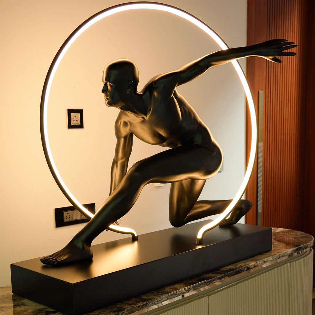 Matte black illuminated human motion sculpture with halo light ring on rectangular base