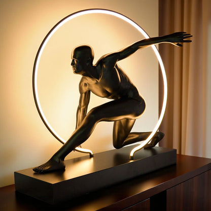 Matte black illuminated human motion sculpture with halo light ring on rectangular base