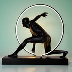 Matte black illuminated human motion sculpture with halo light ring on rectangular base