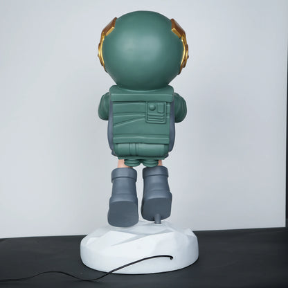 Green astronaut glow lamp holding illuminated sphere on white moon base.