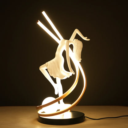 Small white sculpture lamp of a dancing woman with sweeping LED arcs and a glowing orb on a black base.