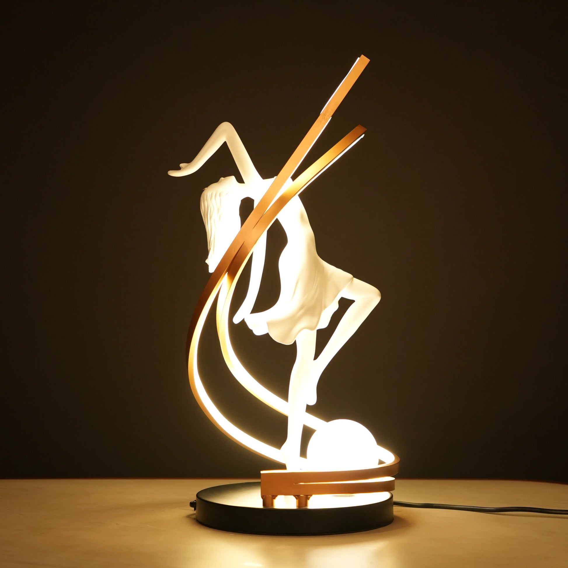 Small white sculpture lamp of a dancing woman with sweeping LED arcs and a glowing orb on a black base.