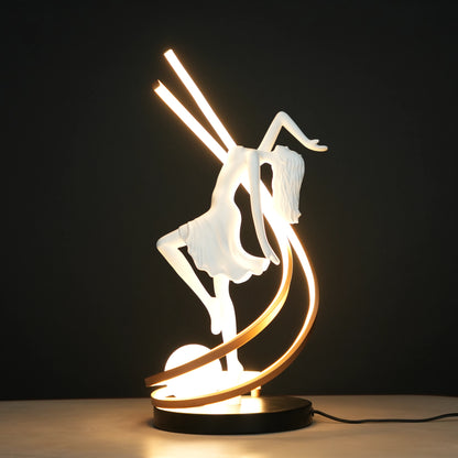 Small white sculpture lamp of a dancing woman with sweeping LED arcs and a glowing orb on a black base.
