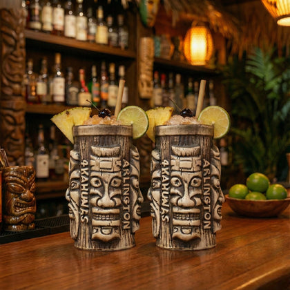 Premium tiki cocktail mugs filled with tropical drinks and pineapple garnish displayed on a stylish tiki bar counter