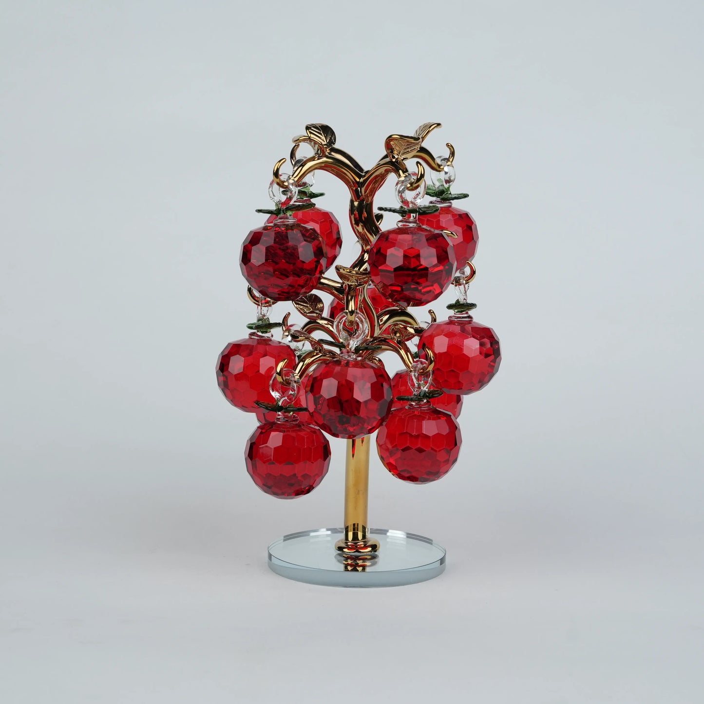 Dense cluster golden crystal apple tree with multiple red faceted apples on a mirrored base.
