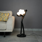 Designer sculptural floor lamp with glowing globe lights and minimalist black human figure structure