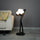 Designer sculptural floor lamp with glowing globe lights and minimalist black human figure structure