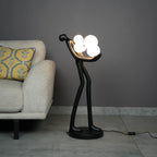 Modern artistic standing floor lamp featuring abstract human silhouette and ambient orb lighting accents