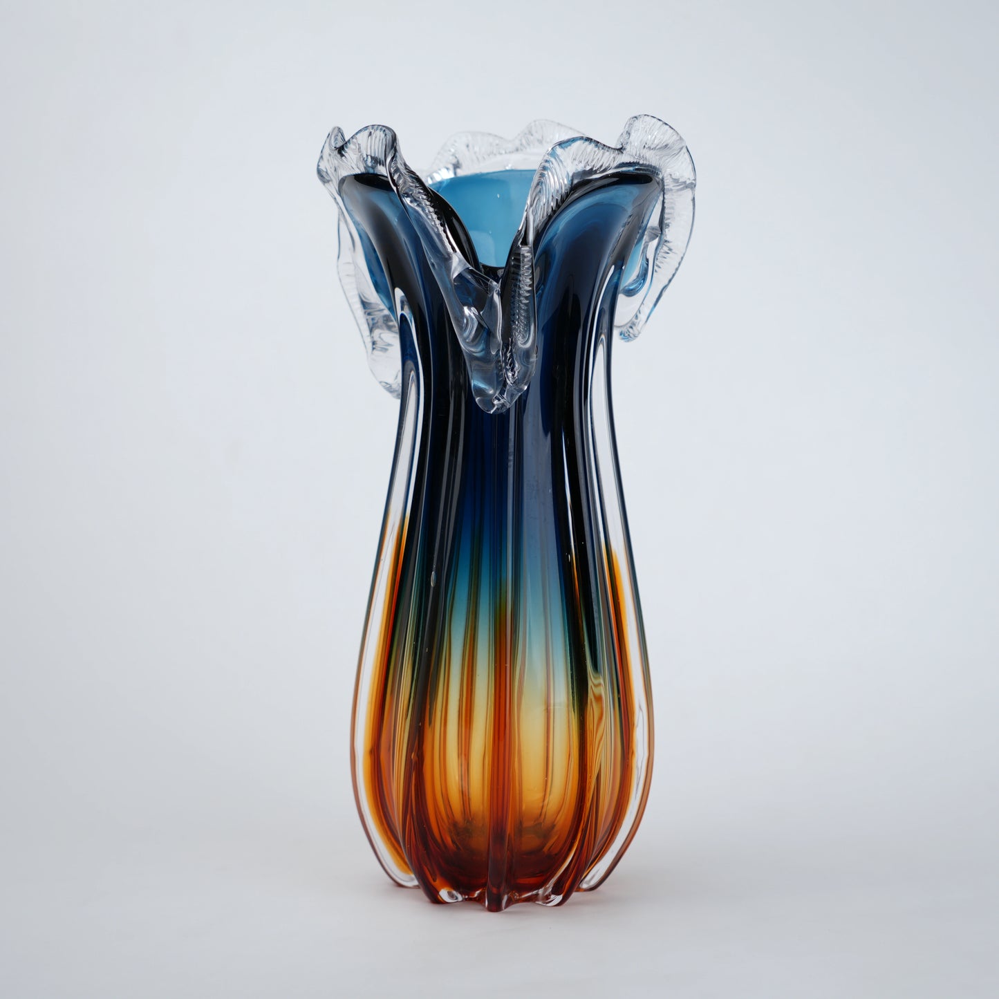 Glass vase with blue and orange gradient on a white background