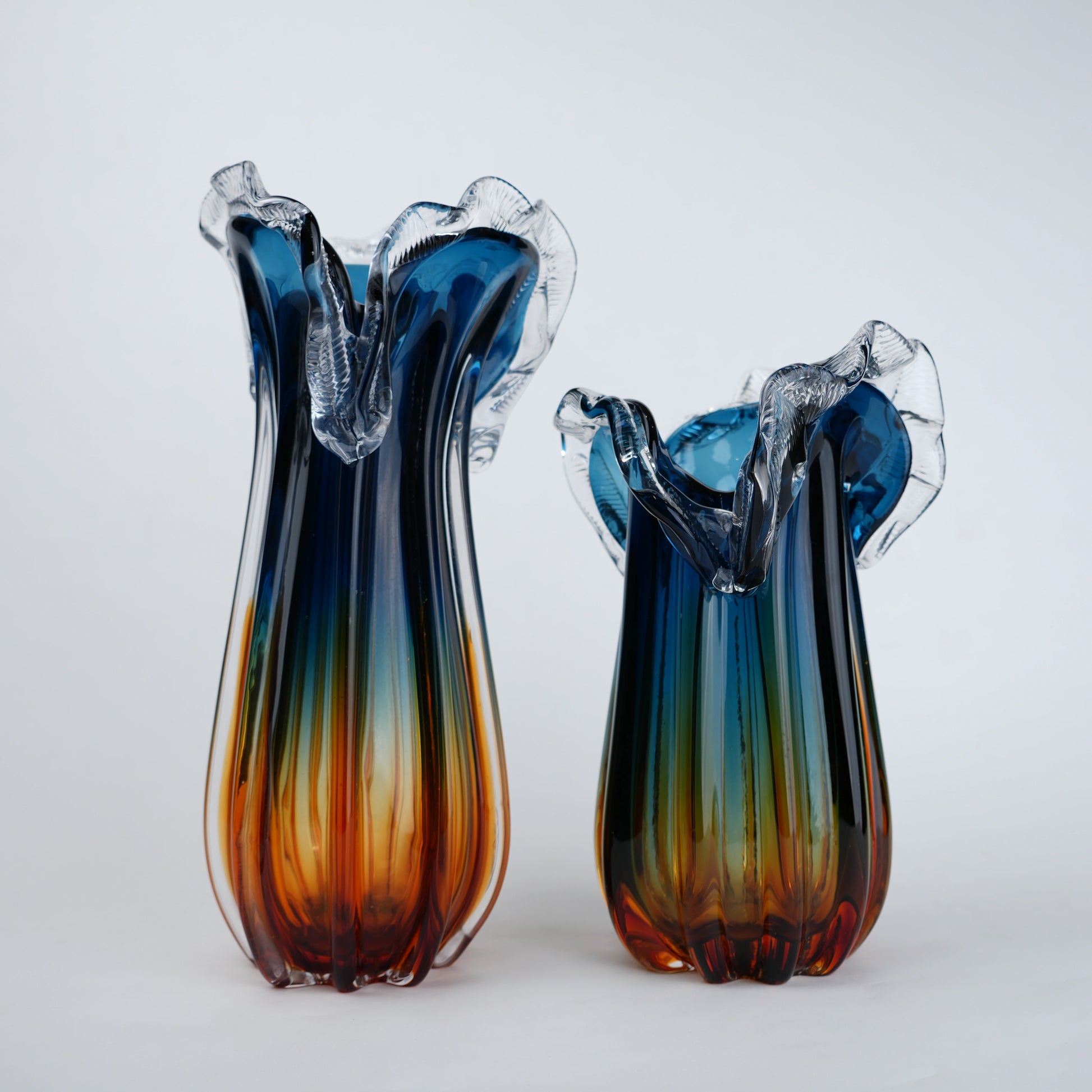 Blue gradient glass vase with multicolor base and clear flared rim