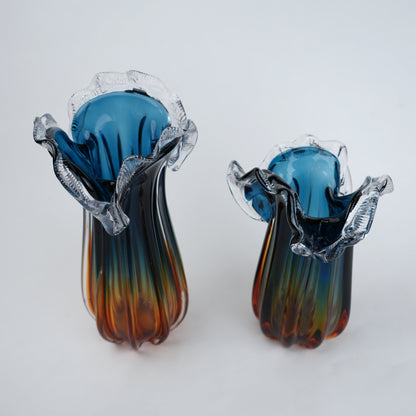 Pair of glass earrings with blue and multicolored design on a white background