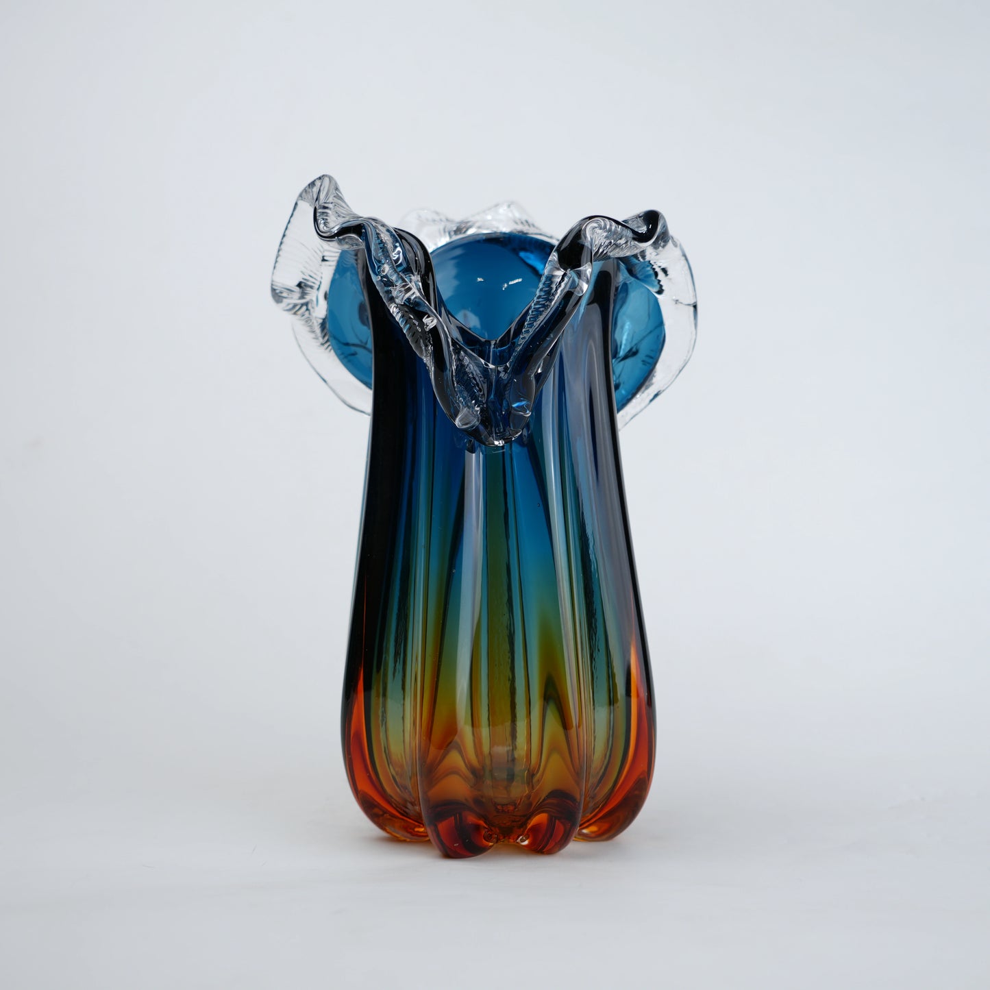 Blue gradient glass vase with multicolor base and clear flared rim