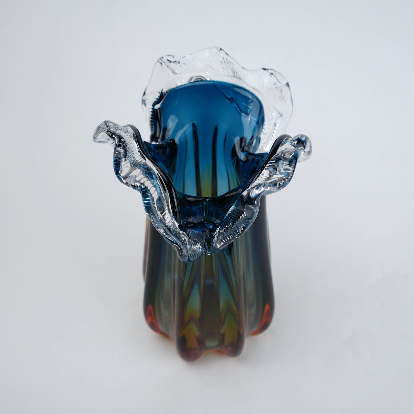 Blue gradient glass vase with multicolor base and clear flared rim