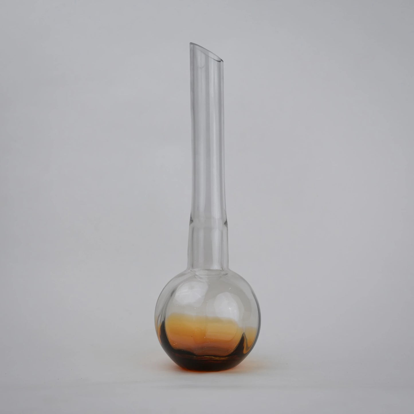 Glass vase with spherical base and elongated cylindrical neck designed for single stem floral arrangements