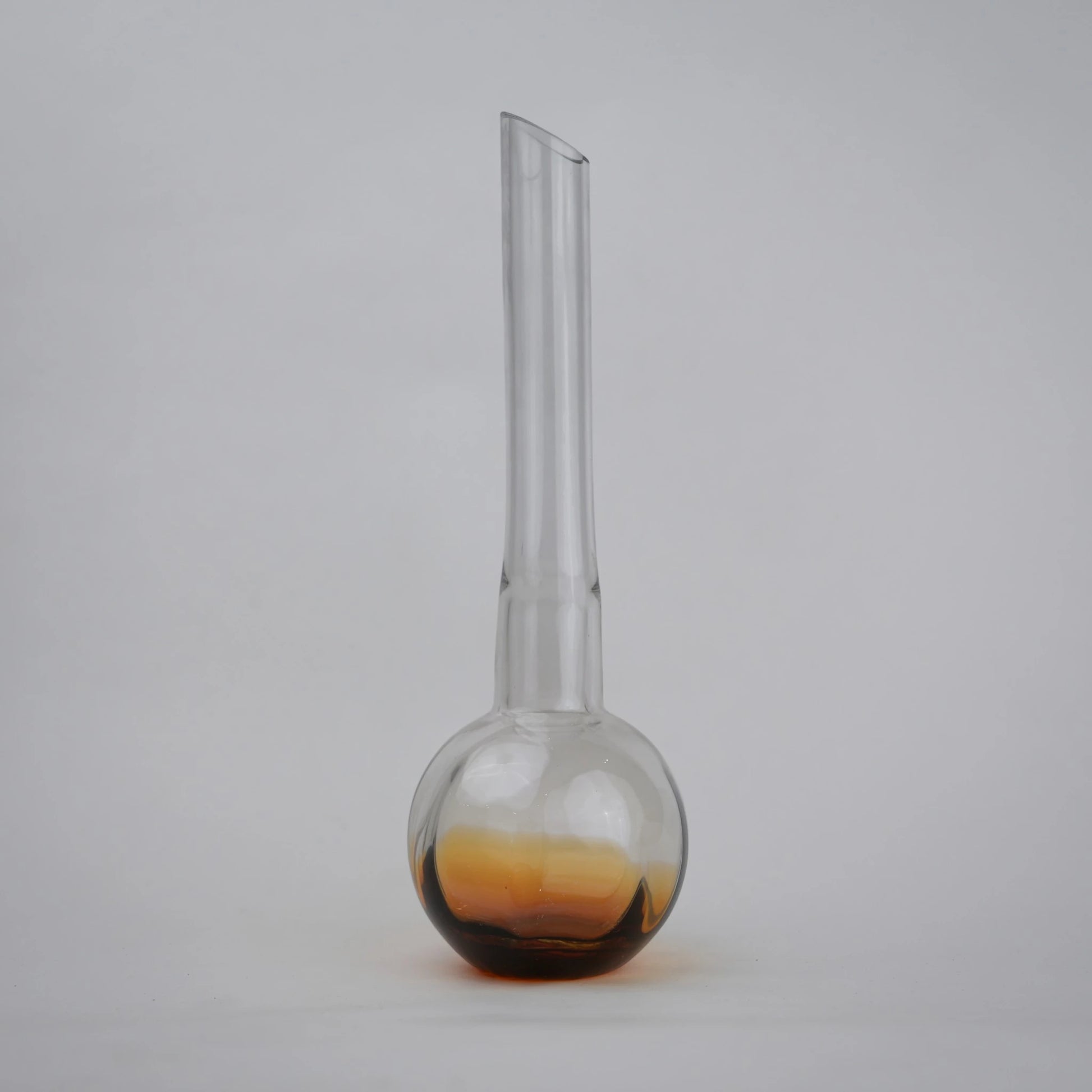 Glass vase with spherical base and elongated cylindrical neck designed for single stem floral arrangements