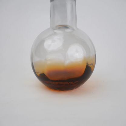 Glass vase with spherical base and elongated cylindrical neck designed for single stem floral arrangements