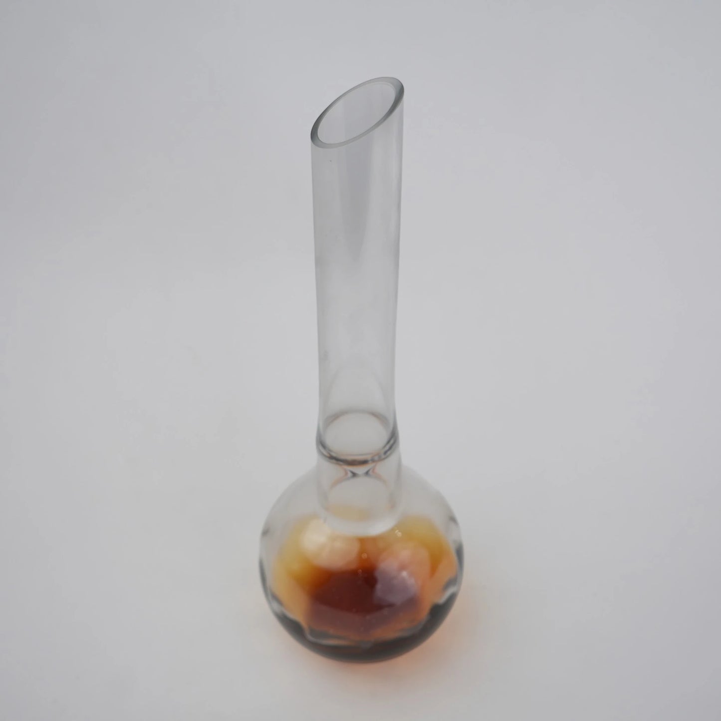 Glass vase with spherical base and elongated cylindrical neck designed for single stem floral arrangements