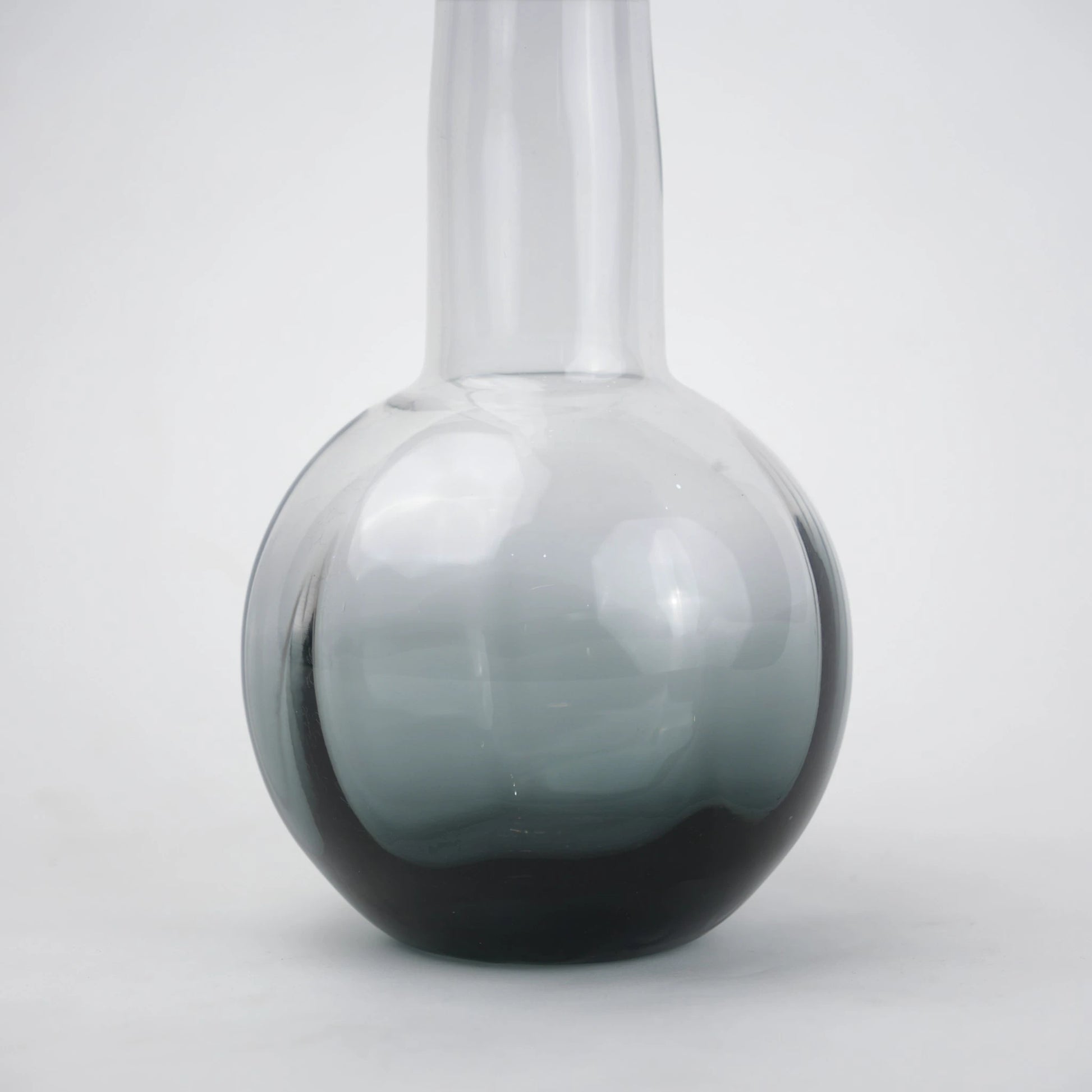 Glass vase with spherical base and elongated cylindrical neck designed for single stem floral arrangements