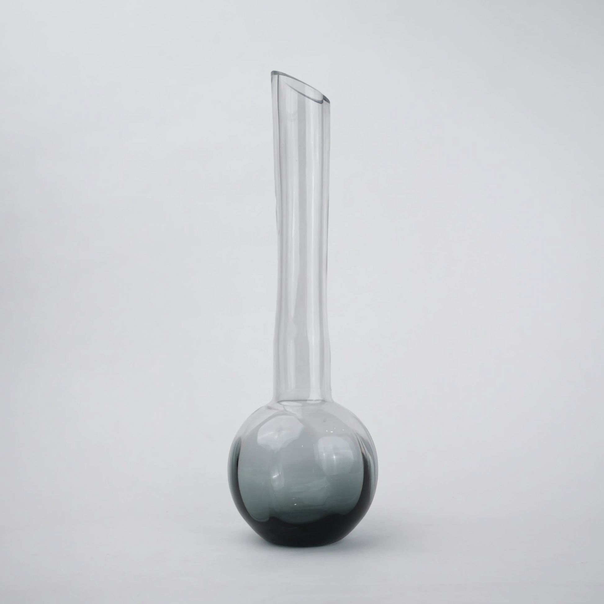 Glass vase with spherical base and elongated cylindrical neck designed for single stem floral arrangements