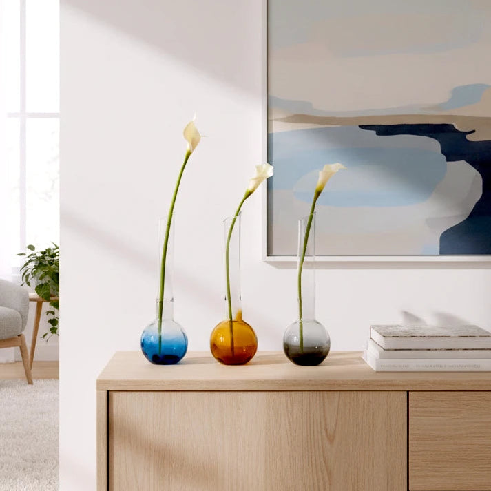 Glass vase with spherical base and elongated cylindrical neck designed for single stem floral arrangements