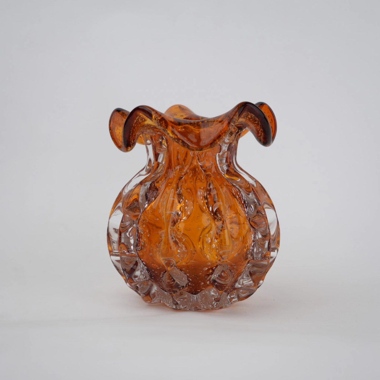 Sculptural amber-toned art glass vase with textured molten-inspired silhouette.