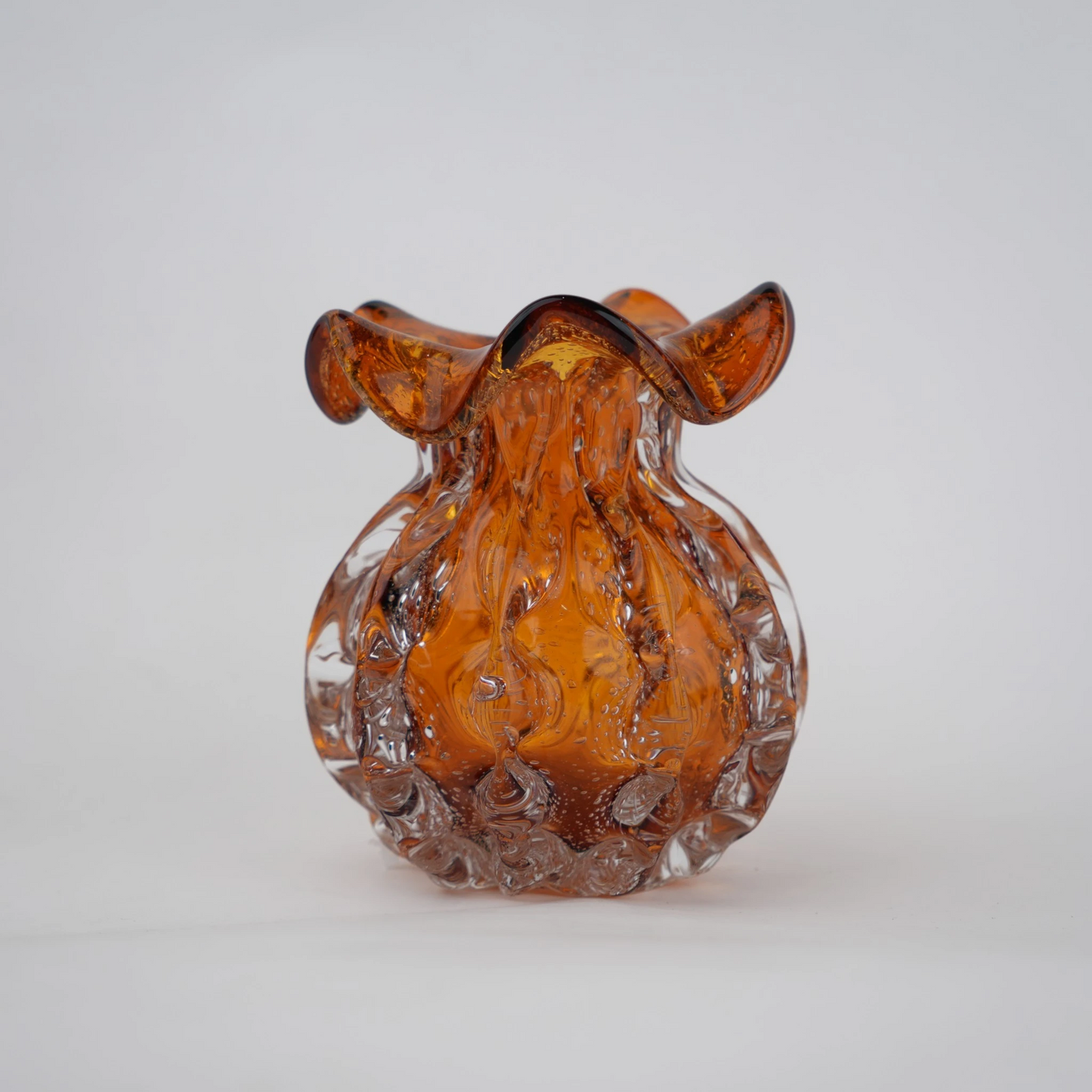 Sculptural amber-toned art glass vase with textured molten-inspired silhouette.