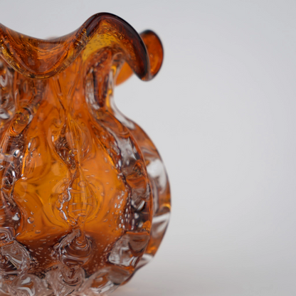 Sculptural amber-toned art glass vase with textured molten-inspired silhouette.
