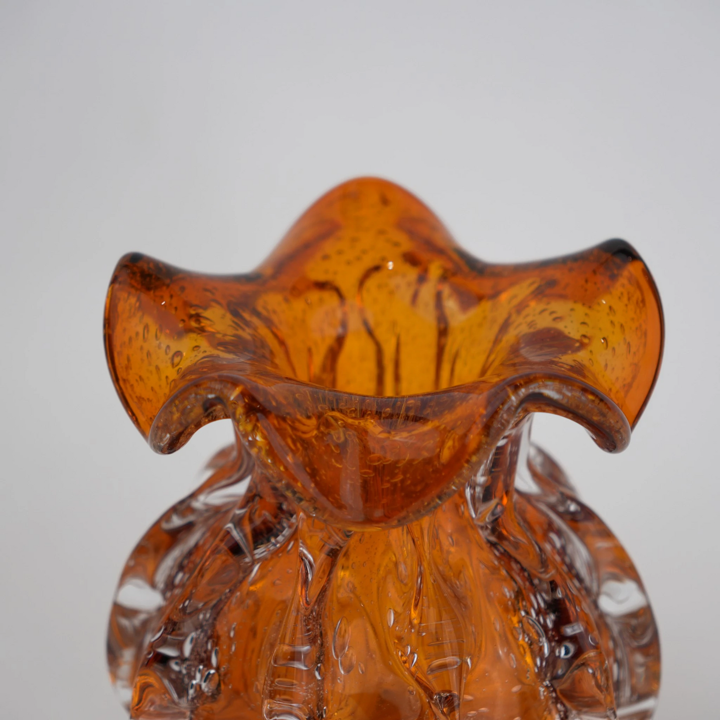 Sculptural amber-toned art glass vase with textured molten-inspired silhouette.