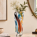 Multicolored twisted sculptural glass vase with elongated form and fluid wave-like contours.