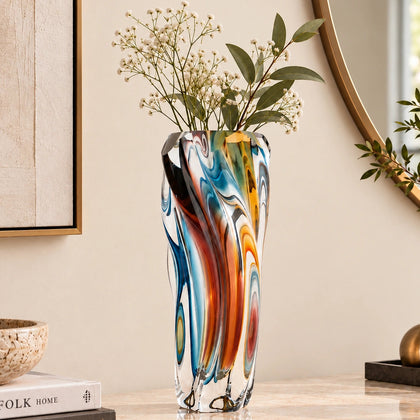 Multicolored twisted sculptural glass vase with elongated form and fluid wave-like contours.