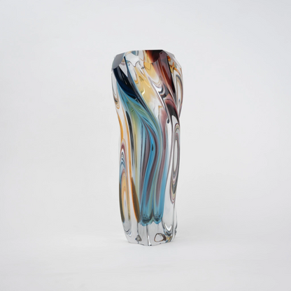 Multicolored twisted sculptural glass vase with elongated form and fluid wave-like contours.