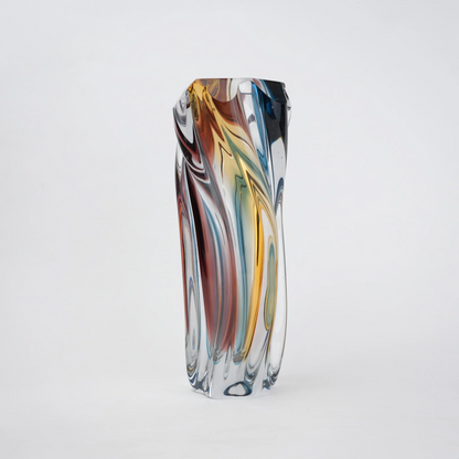 Multicolored twisted sculptural glass vase with elongated form and fluid wave-like contours.