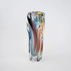 Multicolored twisted sculptural glass vase with elongated form and fluid wave-like contours.