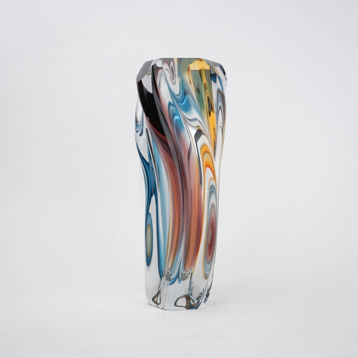 Multicolored twisted sculptural glass vase with elongated form and fluid wave-like contours.
