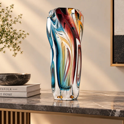 Multicolored twisted sculptural glass vase with elongated form and fluid wave-like contours.