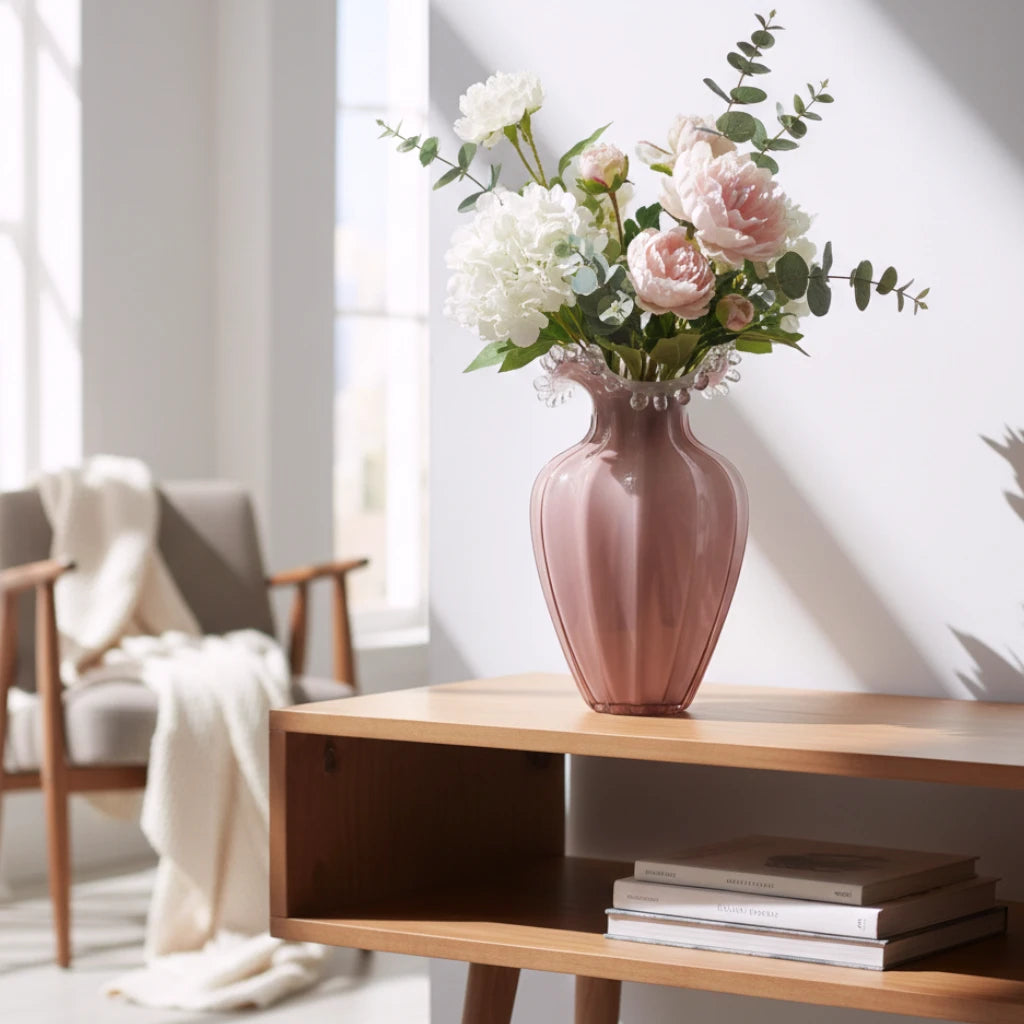 Blush pink translucent glass vase with curved body and sculptural ruffled rim.